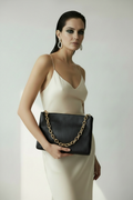 Modella con borsa nera e catena dorata